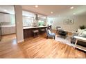 Open-concept living space with hardwood floors, kitchen island, and abundant natural light at 8426 W Woodard Dr, Lakewood, CO 80227