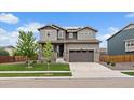 Charming two-story home with a well-manicured lawn, a two-car garage, and stone accents at 13205 E 109Th Ave, Commerce City, CO 80022