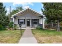 Charming single-story home with a cozy front porch and well-maintained lawn and landscaping at 3866 S King St, Denver, CO 80236