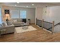 Bright living room showcases hardwood floors, a comfortable sofa, and a staircase with a black railing at 3866 S King St, Denver, CO 80236