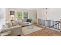 Bright living room with hardwood floors, a comfortable sofa, a glass coffee table, and large windows at 3866 S King St, Denver, CO 80236