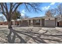 Charming brick home with a well-maintained front yard, a covered porch, and mature shade tree at 61 S 17Th Ave Dr, Brighton, CO 80601