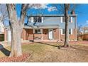 Ranch style home with brick and blue siding exterior, landscaping, and a front porch at 1964 S Leyden St, Denver, CO 80224