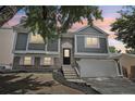 Charming two-story home with a well-manicured front yard and attached garage, illuminated by the soft glow of twilight at 19954 E Dartmouth Ave, Aurora, CO 80013