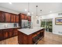 Stylish kitchen boasts dark wood cabinetry, stainless steel appliances, and a center island with barstool seating at 3357 N Akron Ct, Denver, CO 80238