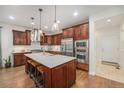 Well-equipped kitchen featuring custom cabinetry, stainless steel appliances, and a center island with seating at 3357 N Akron Ct, Denver, CO 80238