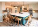Modern kitchen features a large island with seating, stainless steel appliances, and stylish backsplash at 919 Taylor Ln, Erie, CO 80516