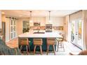 Bright kitchen featuring a large island with bar seating, modern lighting, stainless steel appliances and sliding barn doors at 919 Taylor Ln, Erie, CO 80516