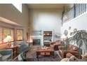 Spacious living room with a fireplace, vaulted ceilings, large windows with wood shutters, and leather furniture at 919 Taylor Ln, Erie, CO 80516
