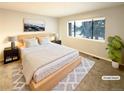 Virtually staged main bedroom with large window and wood floors at 7995 E Mississippi Ave # F11, Denver, CO 80247