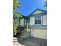 Two-story home with light-blue trim, brick, stairs, and a two-car garage at 19954 E Dartmouth Ave, Aurora, CO 80013