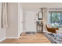 Inviting entryway with hardwood floors, a modern light fixture, comfortable chair and a decorative mirror at 3224 Troy St, Aurora, CO 80011