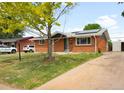 Charming brick home with a well-maintained lawn, mature tree, and a long driveway leading to the backyard at 3341 W 94Th Ave, Westminster, CO 80031