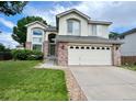 Charming two-story home with brick accents, a two-car garage, and a lush green lawn under a cloudy sky at 12566 Dexter St, Thornton, CO 80241