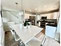 Bright, open kitchen with white cabinets, stainless steel appliances, and a large island with seating at 12566 Dexter St, Thornton, CO 80241