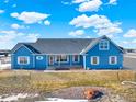 Ranch style home with blue siding, three car garage and covered porch at 767 S Main St, Byers, CO 80103