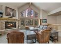 Comfortable living room featuring a stone fireplace, large windows, and cozy seating arrangement perfect for relaxation at 89 Fairview Cir, Breckenridge, CO 80424