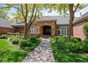 Close up view of brick home featuring a brick entrance and mature landscaping at 5851 S Colorado Blvd, Greenwood Village, CO 80121