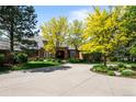 Charming brick home with a circular driveway and mature trees providing shade and curb appeal at 5851 S Colorado Blvd, Greenwood Village, CO 80121