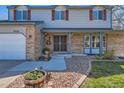 Inviting home exterior featuring brick accents, a landscaped front yard, and decorative shutters at 7926 S Corona Ct, Centennial, CO 80122