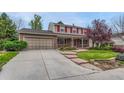 Charming two-story home with brick exterior, landscaped yard, and a two car garage at 7100 S Hudson Cir, Centennial, CO 80122