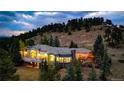 Exterior view of sprawling home with lush landscape, large windows, and outdoor patio area with string lights at 814 Neville Ln, Golden, CO 80401