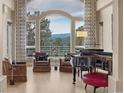Cozy living room featuring a piano, comfortable seating, and a grand arched window with beautiful mountain views at 814 Neville Ln, Golden, CO 80401