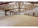 Spacious indoor horse riding arena with ample lighting and a well-maintained sand surface at 5351 Tall Horse Trl, Sedalia, CO 80135