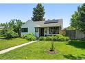Charming home with landscaped front yard and solar panels on the roof at 1240 Ulster St, Denver, CO 80220