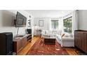 Spacious living room featuring hardwood floors, ample seating, and a modern entertainment setup at 1240 Ulster St, Denver, CO 80220