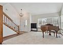 Bright and airy living room featuring plush carpeting, a decorative staircase, and a large picture window at 3311 E Euclid Ave, Centennial, CO 80121