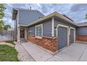 Inviting entrance featuring brick accents, a well-lit walkway, and attached two-car garage at 12682 Fairfax St, Thornton, CO 80241