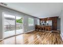Open-concept kitchen featuring stainless steel appliances, breakfast bar, and sliding doors to the patio at 12682 Fairfax St, Thornton, CO 80241