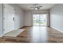 Open-concept living space features stylish flooring, balcony access, and a contemporary ceiling fan at 4451 S Ammons St # 2-204, Littleton, CO 80123