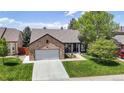 Charming brick home with a well-manicured lawn, inviting entrance, and attached two-car garage at 20855 Omaha Ave, Parker, CO 80138