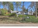 A charming home with lush green lawn is shaded by mature trees providing shade on a bright sunny day at 7785 Westview Dr, Lakewood, CO 80214