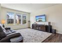 Bright living room featuring hardwood floors, large windows, modern decor, and a comfortable leather sofa at 12797 Clearview St, Firestone, CO 80504