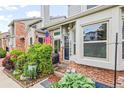 Close up of front entrance of brick townhome with lush flower garden at 15149 E Princeton Pl # B, Aurora, CO 80014