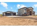 Modern home featuring stone accents, a paved driveway, and a two-car garage at 995 Pinehurst Ct, Bennett, CO 80102