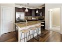 Open kitchen featuring granite counters, dark cabinets, pendant lighting and stainless steel appliances at 303 Inverness S Way # 101, Englewood, CO 80112