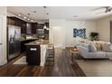 Gourmet kitchen with dark cabinets, granite counters, stainless appliances, and bar stool seating at island at 303 Inverness S Way # 101, Englewood, CO 80112