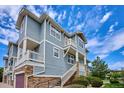 Gray townhome with stone accents, balcony, and attached garage at 9543 Pearl Cir # 101, Parker, CO 80134