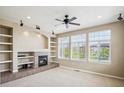 Bright living room with fireplace, built-in shelving, and hardwood floors at 9543 Pearl Cir # 101, Parker, CO 80134