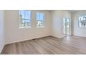 Bright living room with light hardwood floors, white walls, and large windows for plenty of natural light at 2018 S Haleyville Way, Aurora, CO 80018