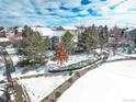 Scenic aerial view of a neighborhood with snow-covered homes, park with sidewalk, and trees at 4053 S Riviera St, Aurora, CO 80018