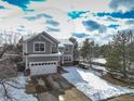 Two-story home featuring an attached garage and a wintery yard with snow at 4053 S Riviera St, Aurora, CO 80018