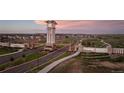 The Aurora Highlands entrance, marked by a clock tower and an American flag at 23909 E 41St Ave, Aurora, CO 80019