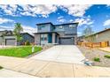 Charming two-story home showcasing a lush green lawn and ample parking on the long driveway at 23909 E 41St Ave, Aurora, CO 80019