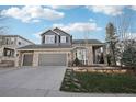Charming two-story home boasts a three-car garage and manicured lawn with beautiful stone accents at 447 Winterthur Way, Highlands Ranch, CO 80129