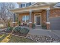 Inviting front porch with stylish seating and stone accents on a well-maintained lawn at 12189 Blackwell Way, Parker, CO 80138